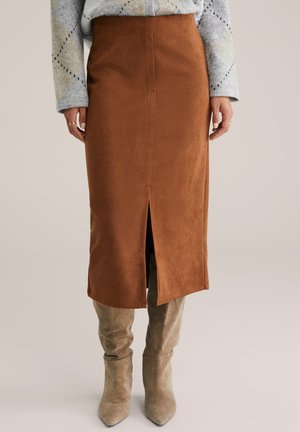 Fustă midi din suede maro cu o fanta frontală, textură netedă și design ajustat. Asortată cu botine taupe până la glezne.