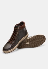 Brown leather high-top shoes with brown suede accents, round toe, and rubber outsole featuring a textured grip pattern. Laced design.