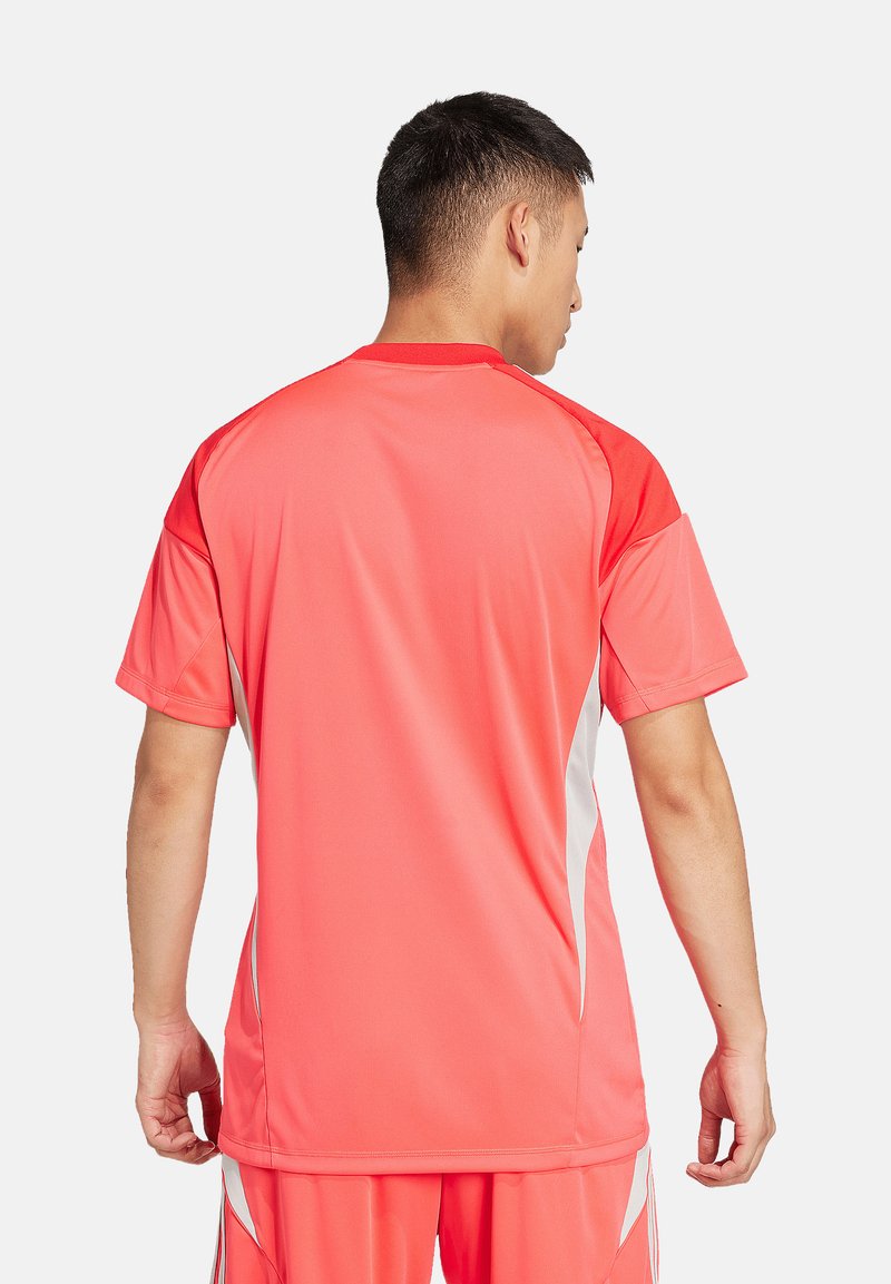 Rotes Sporttrikot mit kurzen Ärmeln, das kontrastierende weiße Seitenpanels aufweist, aus leichtem Material besteht und eine lockere Passform hat.