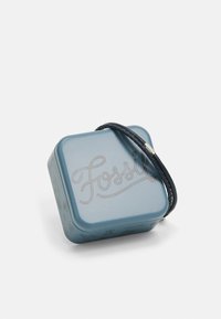 Vierkante blauwe metalen doos met een gestructureerd oppervlak, voorzien van een gevlochten zwartleren handvat. Gegraveerd "Fossil"-ontwerp op het deksel.