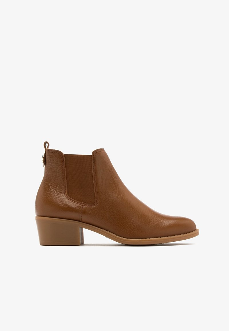 Bottine en cuir marron avec panneaux latéraux élastiques, petit talon et boucle pour un enfilage facile. Texture lisse et design minimaliste.