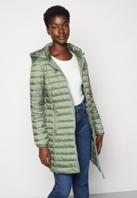 Helle grüne Puffjacke mit Kapuze, ausgestattet mit einem Reißverschluss und zwei Seitentaschen. Der Stoff hat eine glatte, glänzende Textur mit einem gesteppten Muster.