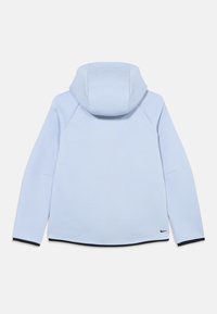 Ανοιχτό μπλε φούτερ με κουκούλα, με λεία υφή, μανίκια ράγλαν, στρογγυλεμένο τελείωμα και μικρό μαύρο λογότυπο στο κάτω αριστερό μέρος.