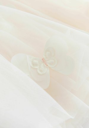 Delikatna bijela prozirna tkanina s slojevitom teksturom koja sadrži mali bijeli ukras od tkanine u obliku leptira s ružičastim šavovima.