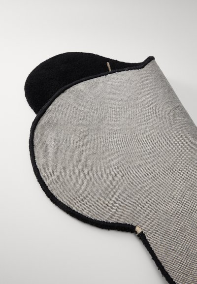 Geweven grijsgaren mat met een afgeronde rand, voorzien van een zwarte achterkant en een subtiel patroon, gedeeltelijk opgerold om beide oppervlakken te tonen.