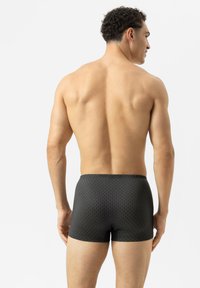 Boxer shorts noirs avec un motif géométrique subtil, fabriqués en tissu lisse, offrant un ajustement agréable et une taille élastique.