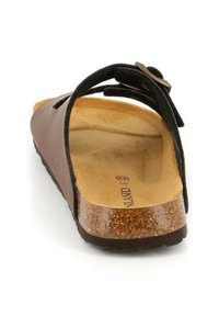 Sandalo marrone con una cinghia nera, sottopiede in sughero e suola testurizzata. Presenta una cinghia regolabile per comfort e vestibilità.
