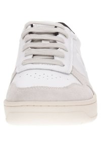 Zapatilla blanca y gris con parte superior de cuero suave y acentos de ante, puntera redonda y cordones planos. Detalle perforado en la caja del dedo del pie.