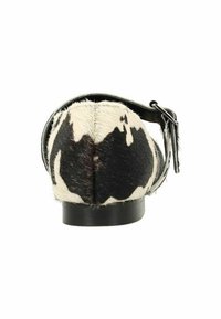 Chaussure plate à pois noirs et blancs avec une finition en fourrure texturée, dotée d'une bride noire et d'un talon bas et solide noir.
