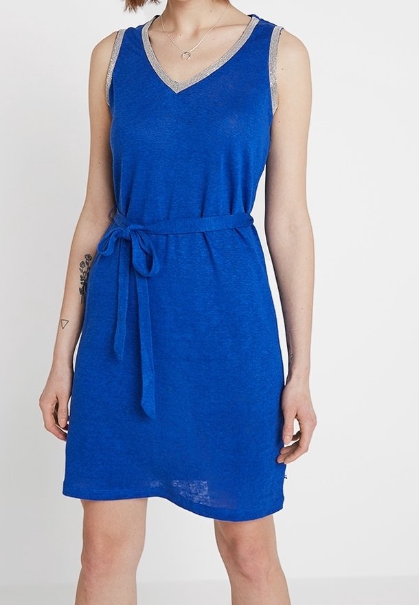 Robe bleue sans manches avec un col en V et un bord argenté aux épaules, dotée d'une ceinture nouée à la taille et d'une coupe décontractée. Texture de tissu douce.