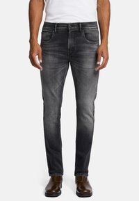 Ciemnoszare dżinsy slim fit wykonane z denimu, z pięcioma kieszeniami, subtelnym wybledzeniem i klasycznym zapięciem na guziki, zestawione z brązowymi botkami za kostkę.