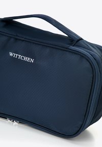 Granatowa nylonowa kosmetyczka z uchwytem na górze, zamknięciem na zamek błyskawiczny i logo "WITTCHEN" w kolorze białym. Teksturowana powierzchnia i kwadratowy kształt.