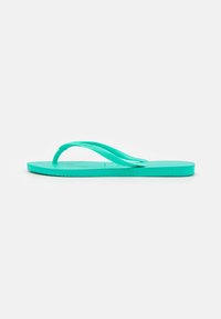 Turkos flip-flop med en texturerad fotbädd, dubbla remmar och en platt sula. Lättvikt och tillverkad av gummimaterial.