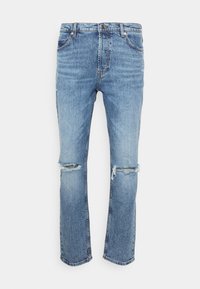Jean en denim bleu clair à coupe droite, avec genoux usés et délavage subtil, doté d'un design classique à cinq poches et de passants pour ceinture.