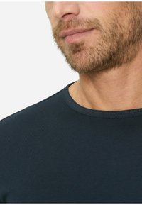 Dunkelblaues T-Shirt mit kurzen Ärmeln und rundem Ausschnitt, ausgestattet mit einer glatten Textur und tailliertem Schnitt, teilweise am Hals präsentiert.