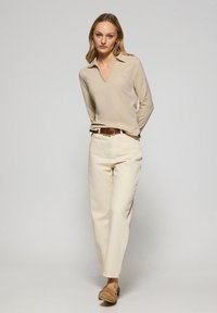 Beige långärmad pikétröja med krage, ljusbeige högmidjade raka jeans och bruna slip-on skor. Minimalistisk design.