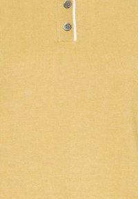 Polo en maille jaune avec trois boutons gris et bordure blanche sur la patte de boutonnage.