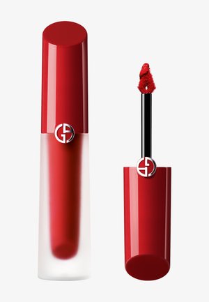 Rouge à lèvres liquide dans un tube en verre transparent avec un capuchon rouge arrondi. Applicateur noir avec une pointe floue rouge. Logo affiché sur le capuchon.