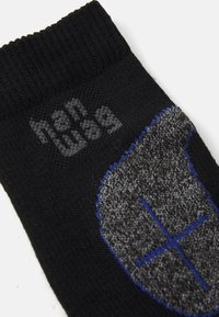 Črne nogavice z rebrovanim robom, s sivo-modrim tkanim logotipom. Tekstura je gladka in srednje debela.