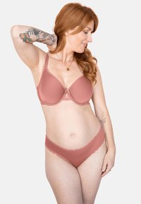 Rose-colored bra with soft, smooth fabric and lace trim. Matching panties with scalloped edges, both featuring seamless design and modest coverage.