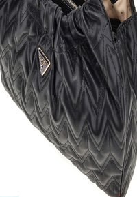 Borsa in pelle nera con un motivo a zig-zag trapuntato, parte superiore arricciata e un accento logo triangolare in argento. Chiusura con zip visibile.