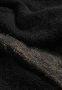 Textile noir et marron avec une texture douce et duveteuse, présentant une base noire foncée et une rayure marron clair se fondant dans le tissu.