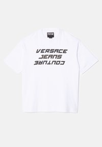 Bílý bavlněný tričko s výrazným černým vertikálním textem "VERSACE JEANS COUTURE." Krátké rukávy a kulatý výstřih.