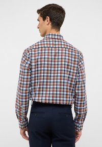 Camicia a maniche lunghe da uomo con un motivo a quadri multicolore in rosso, blu e bianco; presenta un colletto button-down e polsini regolabili.