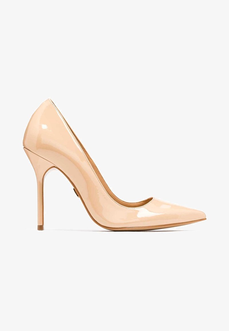 Escarpin en cuir verni beige à talon haut avec bout pointu et talon aiguille sur fond blanc.