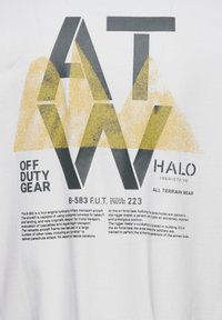 Biała koszulka z wyraźnymi grafikami w czerni i żółci. Tekst zawiera "OFF DUTY GEAR", "HALO" oraz "B-583 F.U.T. 223" z różnymi elementami projektu.