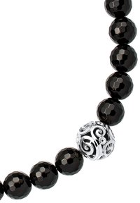 Perlekæde med polerede sorte perler med en facetteret overflade, adskilt af en dekorativ sølvperle med indviklede svungne mønstre.