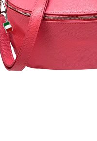 Roze leren schoudertas met een gemarmerde afwerking, zilveren rits en verstelbare strap. Bevat een kleine Italiaanse vlag charm aan de rits.