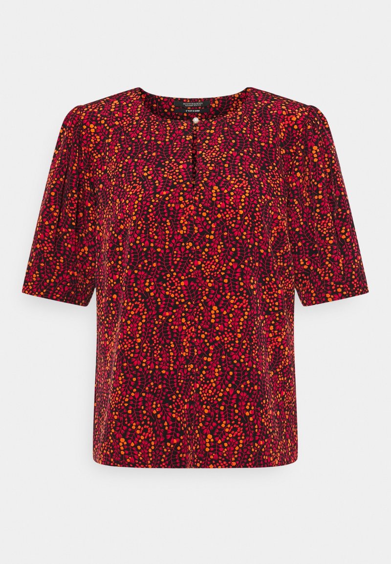 Blouse à manches courtes avec un fond rouge foncé et un motif abstrait vibrant de feuilles et de baies orange et rose, col rond et détail à boutons.