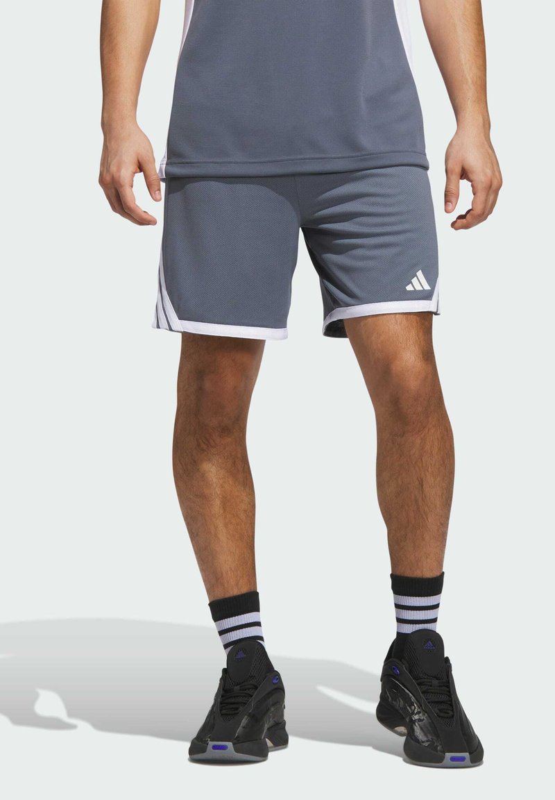 Harmaat urheilushortsit, joissa on valkoisia yksityiskohtia ja teksturoitu materiaali. Vasemmassa lahkeessa on Adidas-logo ja sivuilla on raidat.