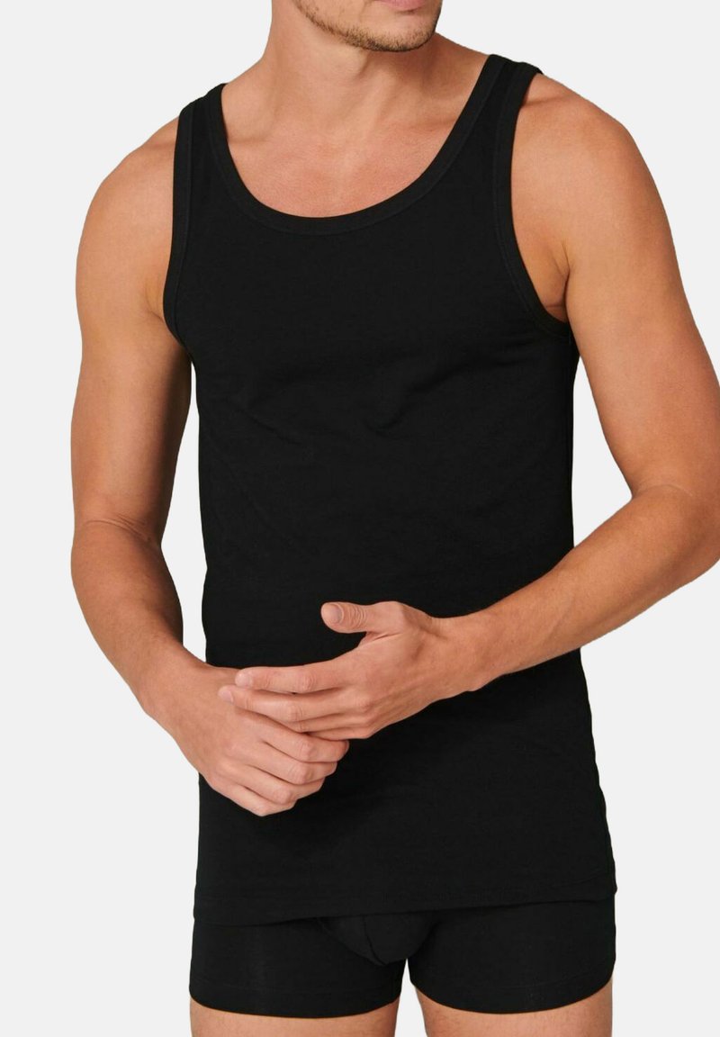 Black cotton tank top with a round neckline, fitted design, and textured fabric, paired with black shorts. No patterns or accents present.