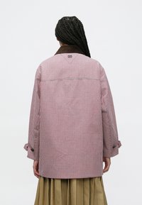 Καρό πουκάμισο με κόκκινα και λευκά κουμπιά, με καφέ γιακά, χαλαρή εφαρμογή, μακριά μανίκια και λεπτομέρεια yoke στην πλάτη.