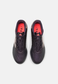 Zapatillas deportivas negras con parte superior de cuero texturizado, acentos rosas en la plantilla y tres rayas blancas a los lados. Diseño tradicional con cordones.