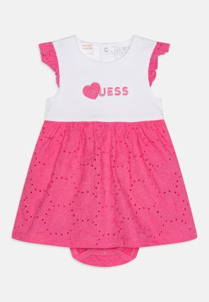 Hvid og lyserød babykjole med blomsterblonde nederdel, flæseærmer og "Guess" logo broderet med et hjerte på brystet.