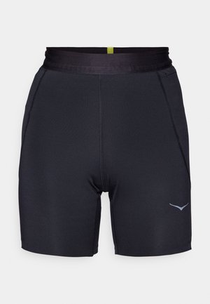 Svarte treningsshorts med en tettsittende design, glatt tekstur, elastisk midje og en subtil grå logo på venstre side.