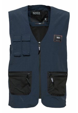 Marinblå väst med meshfickor och zippered stängningar. Har en frontdragkedja, två bröstfickor och en tyg etikett. Lätt material.