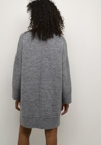 Grijze gebreide trui-jurk met lange mouwen, geribbelde manchetten en zoom. Zachte textuur met een losse pasvorm en een rugnaaddetail.
