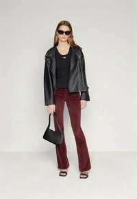 Black leather biker jacket, fitted black tank top, burgundy flared corduroy pants, black handbag, and open-toed black heeled sandals.