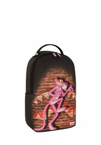 Zaino nero con un grande personaggio dei cartoni animati rosa su un motivo a mattoni texturizzato. Dettagli includono zip rosa e una forma arrotondata.