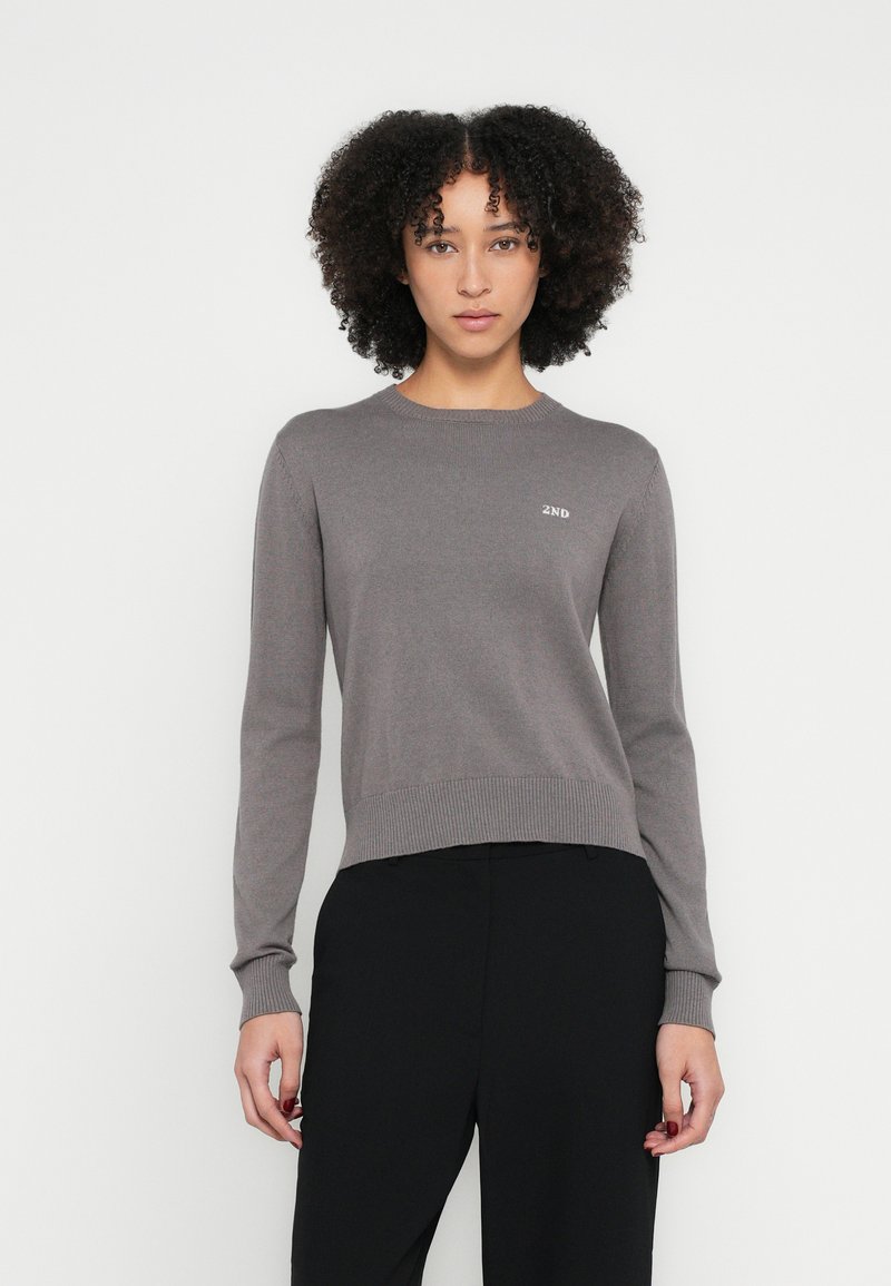Maglione grigio lavorato a maglia con maniche lunghe, polsini a coste e scollo rotondo. Presenta un logo "2ND" sottile sul petto. Design minimalista.