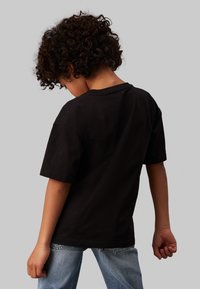 Calvin Klein Jeans MONOGRAM GRID RELAXED - Triko s potiskem - black