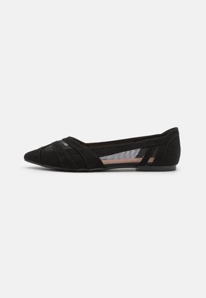 Chaussure plate noire à bout pointu avec brides croisées et panneaux latéraux en mesh, talon bas et matériau à texture lisse.