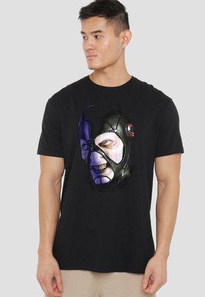 Schwarzes Baumwoll-T-Shirt mit einem Frontgrafik eines maskierten Gesichts in lila und weißen Akzenten. Kurze Ärmel und Rundhalsausschnitt.