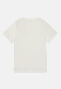T-shirt à manches courtes et col rond en coton écru, avec une texture lisse et un design épuré et minimal sans logos ni motifs visibles.