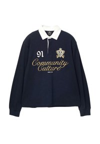 Marineblaues Langarm-Polohemd mit weißem Kragen, bestickt mit goldenem Text "Community Culture" und der Nummer "91", sowie einem dekorativen Wappen.