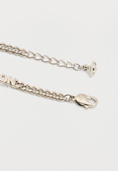 Ασημένιο κολιέ αλυσίδα με κούμπωμα σε σχήμα αστακού και ένα μικρό μενταγιόν σε σχήμα πλανήτη στην προέκταση της αλυσίδας, σε λευκό φόντο.